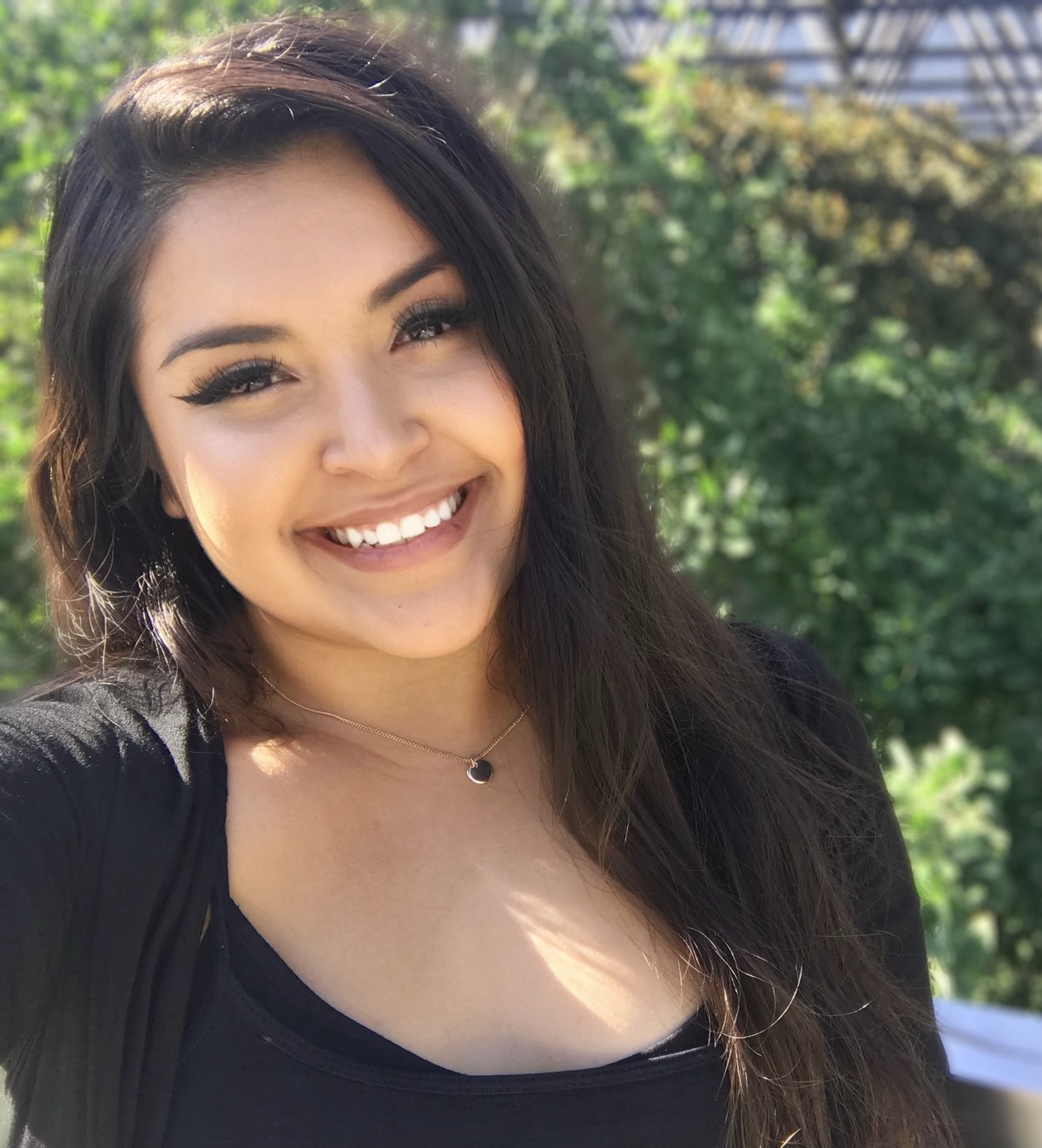 Erika smiling outside in the sunshine